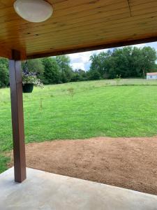 a wooden porch with a view of a field at Gîte du Phare in Lanquais