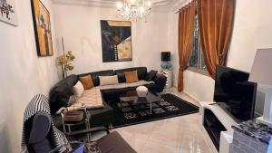 a living room with a couch and a tv at Villa Michel in Tamraght Ouzdar