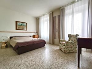 a bedroom with a bed and a chair and a desk at Domus Mazzoni in Capannori