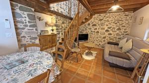 a living room with a bed and a couch at Le clédier de cherveix in Solignac