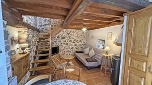 a living room with a couch and a staircase at Le clédier de cherveix in Solignac