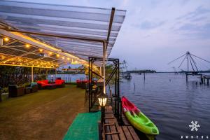 a restaurant with a boat on the water at Zostel Kochi, Kumbalangi in Cochin