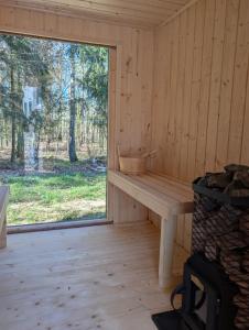 a room with a window and a bench in a cabin at Leno Tu - Domki przy jeziorze z sauną i banią in Ciemno