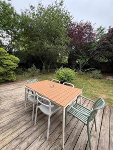a wooden table and chairs on a wooden deck at Casa Limon, Charm & Serenity in Cesson-Sévigné