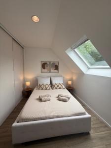 a bedroom with a bed with two pillows and a window at Casa Limon, Charm & Serenity in Cesson-Sévigné