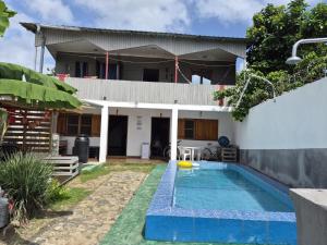 a house with a swimming pool in front of it at Hostel Sao Gabriel - new pool in São Tomé