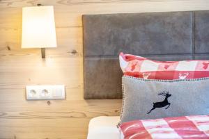a bedroom with a bed with a deer pillow and a lamp at Altvogtshof in Furtwangen