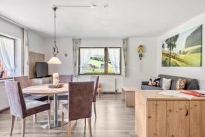 a living room and dining room with a table and a couch at Altvogtshof in Furtwangen
