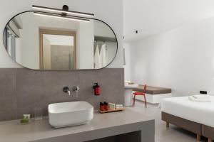 a bathroom with a sink and a mirror at Spanos Apartments - Andros in Agios Petros +53 photos