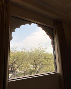 a window with a view of a tree at Laal Haveli Kukas in Jaipur