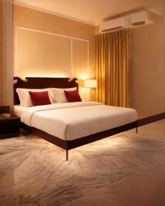 a large bedroom with a large bed with red pillows at Laal Haveli Kukas in Jaipur