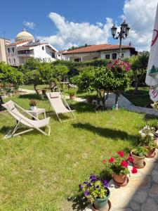 two lawn chairs and flowers in a yard at Villa Starova in Berat