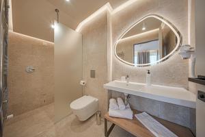 a bathroom with a sink and a toilet and a mirror at Aparthotel SamElyon in Samokov
