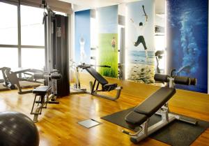 a gym with exercise equipment and a wall with a mural at Scandic Espoo in Espoo
