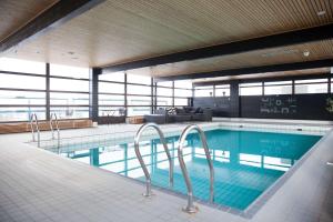 a large swimming pool in a building with a view at Scandic Espoo in Espoo