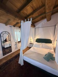 a bedroom with a white bed with a canopy at Claustrum di Colforcella in Cascia +93 photos