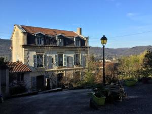 une maison ancienne avec un éclairage de rue devant elle dans l'établissement Le Clocher, à Saint-Julien