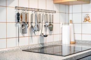 a kitchen counter with utensils hanging on a wall at Altvogtshof in Furtwangen +27 photos