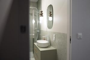 a bathroom with a sink and a shower with a mirror at Calma Apartament Moderato in Starogard Gdański