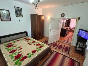 a bedroom with a bed with red flowers on it at Krausz Chocolate Guesthouse in Sîntimbru