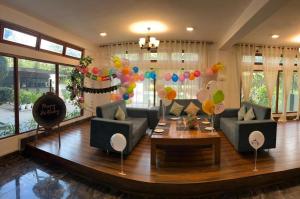a living room with couches and a table and balloons at Peridott Inn in Jaigaon