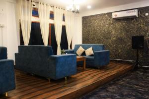 a living room with two blue chairs and a table at Peridott Inn in Jaigaon