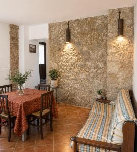 a dining room with a table and chairs and a stone wall at Affittacamere Isidoro in Zaccanopoli