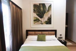 a bedroom with a bed and a picture on the wall at Peridott Inn in Jaigaon +22 photos