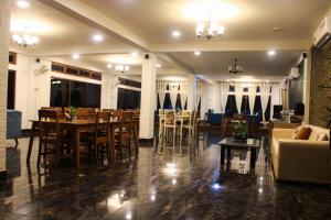 a living room with a table and chairs and a couch at Peridott Inn in Jaigaon