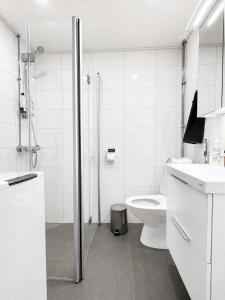 a white bathroom with a toilet and a shower at Aava's apt. FREE Parking in Pori +9 photos