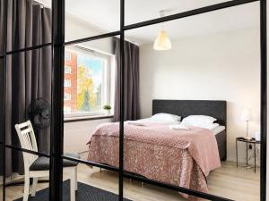 a bedroom with a bed and a window at Aava's apt. FREE Parking in Pori