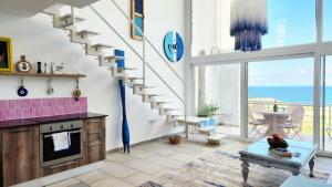 a living room with a spiral staircase in a house at Blue Marine in Kalogrea