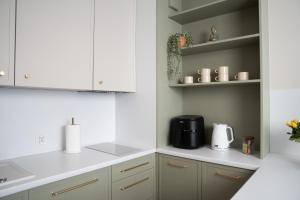 a kitchen with white cabinets and a coffee maker at Calma Apartament Moderato in Starogard Gdański +9 photos