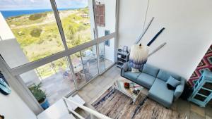 a living room with a couch and a large window at Blue Marine in Kalogrea