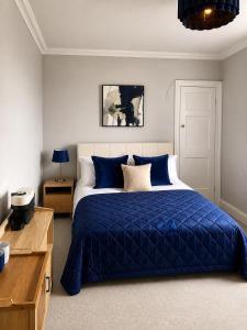 a bedroom with a blue bed and a desk at Station Hotel in Burghead