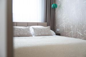 a bed with white sheets and pillows in a bedroom at Calma Apartament Moderato in Starogard Gdański