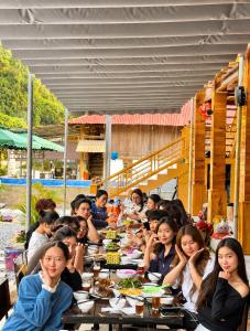 a group of people sitting at tables eating food at Bản Lướt Homestay -Ngọc Chiến Hotspring in Sơn La