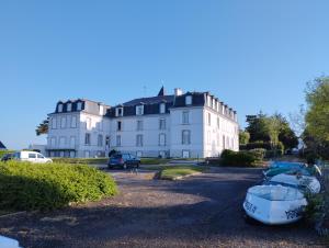 a large white building with boats in front of it at studio moderne les pieds dans l'eau in Larmor-Baden
