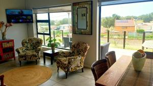 a living room with a table and chairs and a large window at Hartmel Sea Deck in Hartenbos