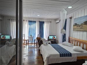 a bedroom with two beds and a table and chairs at Hostel Sao Gabriel - new pool in São Tomé +87 photos