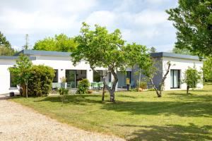 a white house with trees in front of it at La maison du verger in Loctudy