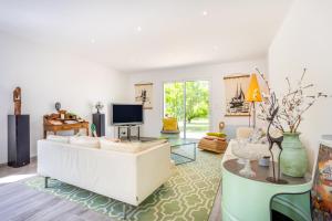 a living room with a white couch and a tv at La maison du verger in Loctudy