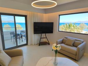 a living room with a television and a couch and a table at Kos Palace in Tigaki