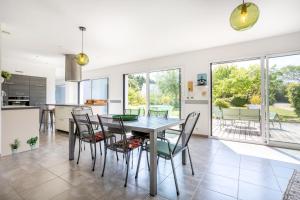 a kitchen and dining room with a table and chairs at La maison du verger in Loctudy