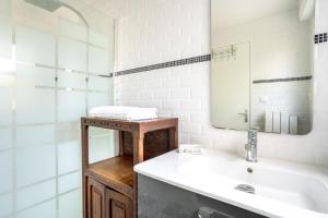 a bathroom with a sink and a mirror and a tub at L'escale bleue in Plomeur +23 photos