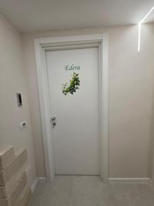 a white door with a plant sign on it at Flag in Torre del Greco +4 photos