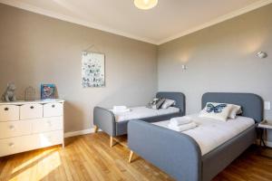 a living room with two beds and a dresser at L'escale bleue in Plomeur