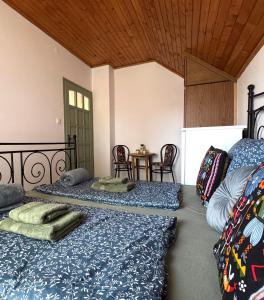 a bedroom with two beds and a table with chairs at Kovács Vendégház in Harkány