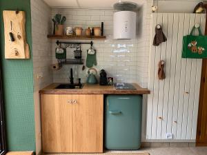 a small kitchen with a blue refrigerator in it at Éco-Gîte "La Chouette Verte" - Eco-Lodge "The Green Owl" in Wangenbourg
