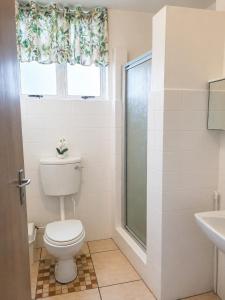 a bathroom with a toilet and a window at Scottburgh Peacehaven Holiday Flat 202 in Scottburgh +5 photos